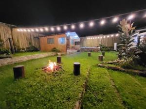 a backyard with a fire in the grass at night at Glamping Site walking distance to Majayjay Falls in Amonoy