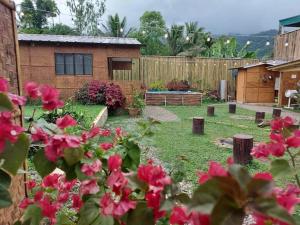 un jardín con flores rosas y una valla de madera en Glamping Site walking distance to Majayjay Falls, en Amonoy