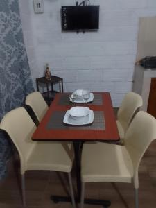 a dining room table with white chairs and a plate on it at Apart Cabaña KTIK in San Bernardo del Viento