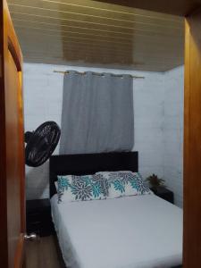 a bedroom with a bed with a gray curtain at Apart Cabaña KTIK in San Bernardo del Viento