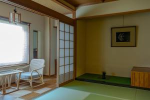 a room with a table and chairs and a window at Sensui in Toyooka