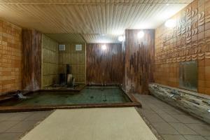 an empty bathroom with a shower with wooden walls at Sensui in Toyooka