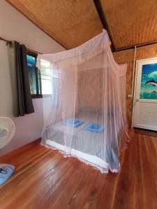 a bedroom with a bed with a net at Bamboo Hut Bangalow in Ko Mook