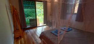 a person standing on a bed in a room at Bamboo Hut Bangalow in Ko Mook