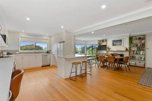阿波罗湾Miren Cottage Holiday Home Free Wi-Fi的配有桌椅的厨房和客厅