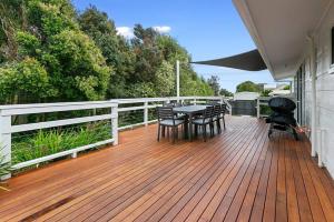 阿波罗湾Miren Cottage Holiday Home Free Wi-Fi的一个有桌子和椅子的木甲板