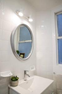 Baño blanco con lavabo y espejo en Loft de Buenos Aires en Buenos Aires