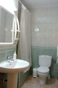 托爾拉的住宿－呂西安富希奧布里特旅舍，浴室配有白色卫生间和盥洗盆。