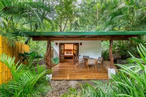 a wooden deck in the middle of a forest at Makanas Beach Bungalows in Santa Teresa Beach