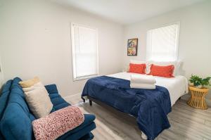 a bedroom with a bed and a blue couch at Homey Cozy Newly Renovated Stylish&chic 7 Guests in Tampa