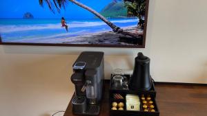 una macchinetta del caffè su un tavolo con una foto sul muro di Vue Mer & Rocher - Okavango Blue Studio a Le Diamant