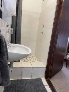 un baño con lavabo y ducha en Kloof at Casa Esda, en Jeffreys Bay