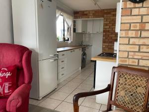 cocina con nevera blanca y silla roja en Kloof at Casa Esda, en Jeffreys Bay 10 fotos más