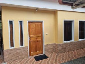 Casa pequeña con puerta y ventanas marrones en Cristina - Hotel Familiar, en Tambor
