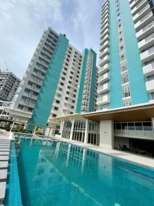 a swimming pool in front of some tall buildings at mesavirre garden residences in Bacolod