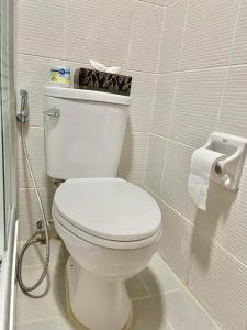 a bathroom with a white toilet with a roll of toilet paper at mesavirre garden residences in Bacolod
