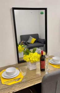 a dining room table with yellow flowers and a mirror at mesavirre garden residences in Bacolod