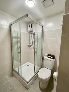 a bathroom with a shower stall and a toilet at mesavirre garden residences in Bacolod