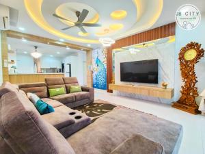a living room with a couch and a flat screen tv at Pangsapuri Meridian by RR JBcity in Nusajaya