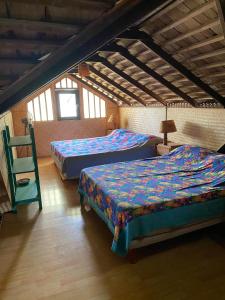 a bedroom with two beds and a chair at Beach de rêve de moorea in Hauru