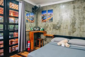 a bedroom with a blue bed and a window at OKEANOS HOTEL in Moalboal