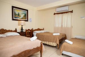 una camera d'albergo con due letti e una finestra di Hotel Internacional Palmerola a Comayagua