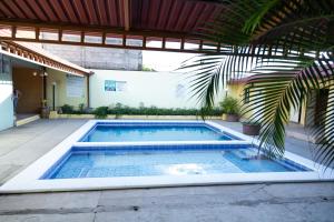una piscina con una palma accanto a un edificio di Hotel Internacional Palmerola a Comayagua