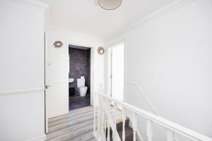 eine weiße Treppe in einem weißen Haus mit einem Bad in der Unterkunft 6 Bedroom Larger group House with Parking Corringham Stanford Le Hope in Horndon on the Hill + 50 Fotos