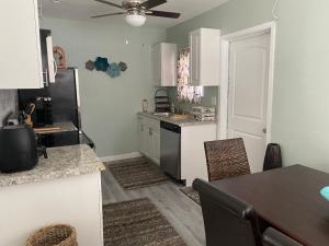 a kitchen with white cabinets and a black refrigerator at 5 min to Beaches! Biz Ready Large Living Room Fenced Backyard Patio Grill Firepit Driveway Parking in Lake Worth