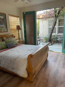 een slaapkamer met een groot bed en een glazen schuifdeur bij Quaint Cochella Music Festival Casita in Indio