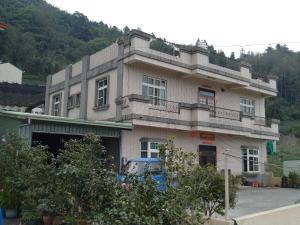 a building with a lot of windows on top of it at Ming Camphor Homestay in Meishan