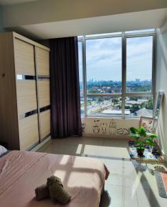 um quarto com uma cama e uma grande janela em Rainforest City House Greenfield Regency - Paradigm, Sutera & UTM area em Johor Bahru