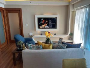 sala de estar con sofá azul y TV en Exclusivo Apto Piscina Bella Vista Centro de Ciudad! en Santo Domingo