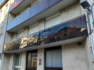 um edifício com um reflexo de uma árvore na janela em Appartement Saint-Chamond, 4 pièces, 6 personnes - FR-1-496-269 em Saint-Chamond