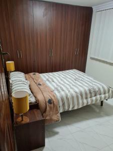 sypialnia z łóżkiem z drewnianą ścianą w obiekcie Koru Farm Retreat w mieście Muhoroni