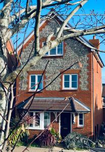 a red brick house with two windows on it at Angmering Home in Angmering