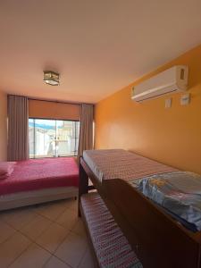 a hotel room with two beds and a window at Casa 3Jotas in Garopaba