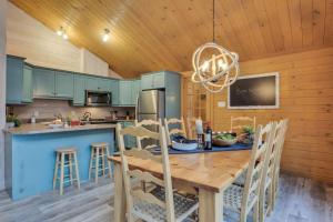 una cucina con tavolo e sedie in una cabina di Le Chic Harfang Mont Tremblant a Lac-Superieur