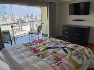 een slaapkamer met een bed en een groot raam bij Book in Miraflores - Lima in Lima