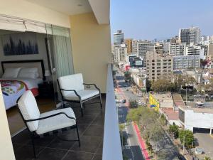 a bedroom with a bed and a view of a city at Book in Miraflores - Lima in Lima
