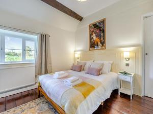 a bedroom with a large white bed with a window at The Moat House in Cudworth