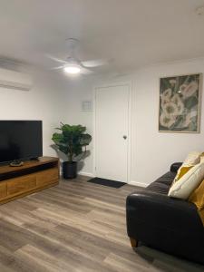 a living room with a couch and a flat screen tv at Morros Place in Hay