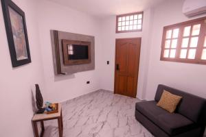 a living room with a couch and a tv at Hotel Santa Fe in Puerto Ayora