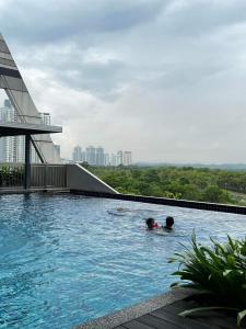 依斯干達公主城的住宿－D Bunga 1 MOSLIM Homestay Pool View Legoland Nusajaya，两人在大楼的游泳池游泳