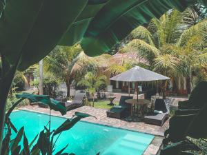 珀尼達島的住宿－The Valley Green Cottage，一个带椅子和桌子的游泳池以及一把遮阳伞