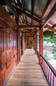 un pasillo de una casa con paredes de madera y una pasarela de madera en SAKURA House - Hoa Ban, en Mộc Châu