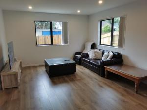 ein Wohnzimmer mit einem Sofa und einem Couchtisch in der Unterkunft Lovely House in Central Papatoetoe in Auckland