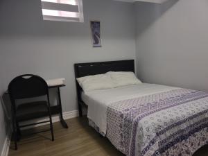 Prestige Accommodation Self-contained 2 Bedrooms Suite في أجاكس: غرفة نوم بسرير وكرسي ومكتب