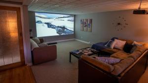 a living room with a couch and a large screen at Sunset Tides in Oak Haven