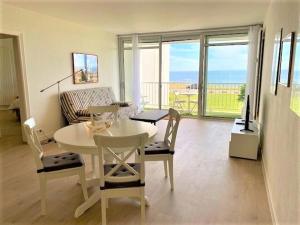 een woonkamer met een tafel en stoelen en de oceaan bij Appartement Quiberon, 2 pièces, 4 personnes - FR-1-478-147 in Quiberon